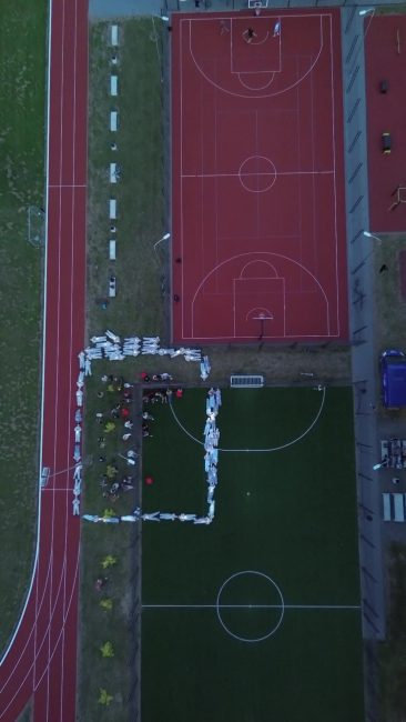 5 baltas kambarysRenatos Karvelis poetinis performansas Gyvi pamatai 2024 rugsėjo 5 d Tauragės Mažvydo progimnazijos stadionas Nuotrauka iš drono